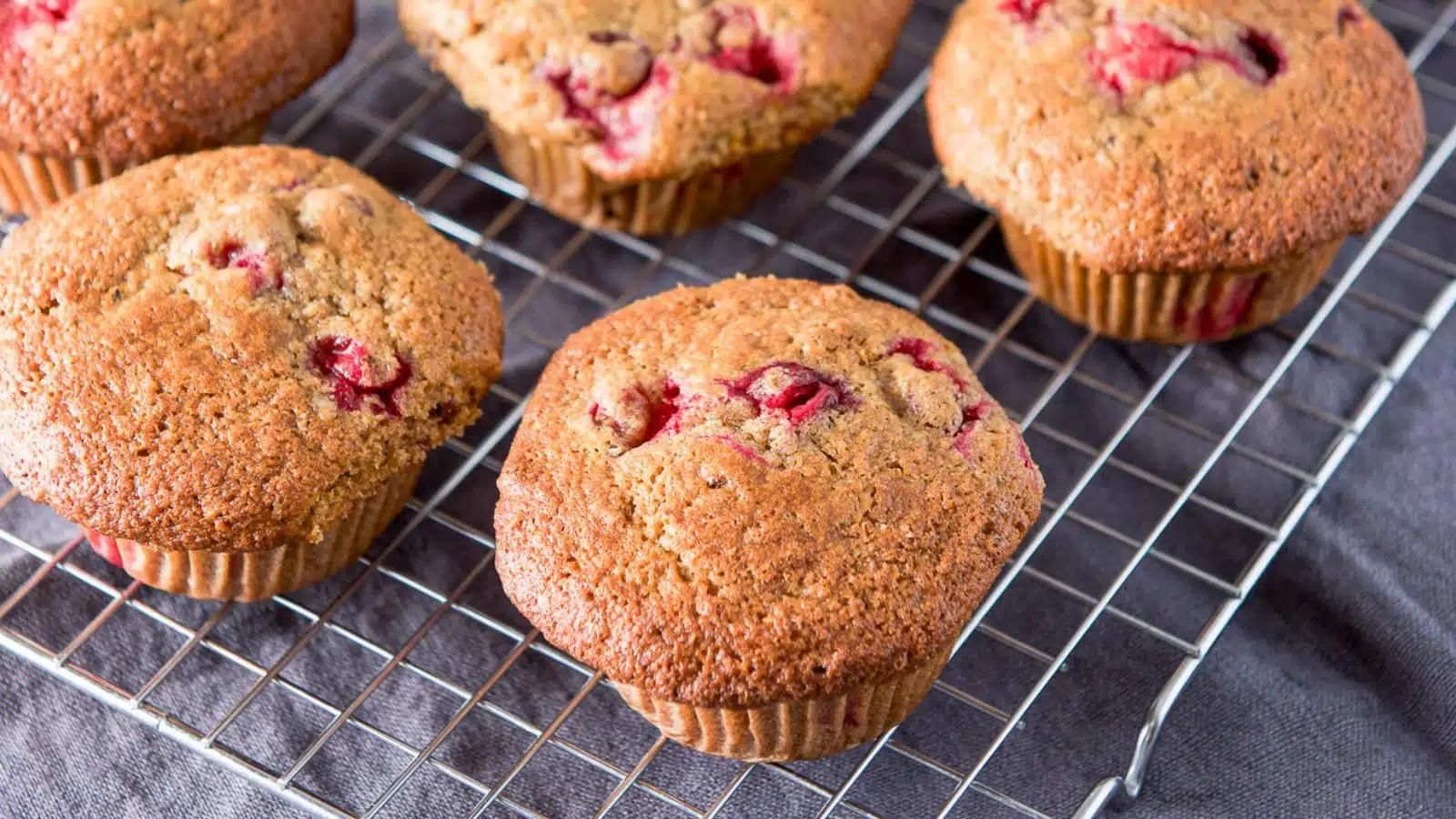 Closeup of orange muffins on a cooling rack.