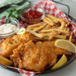 Large platter with crispy battered fish, French fries and dipping sauces.