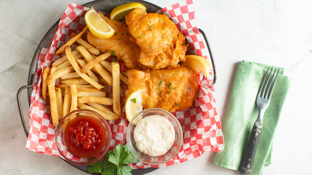 Overhead photo of fried fish in a basket with fries.