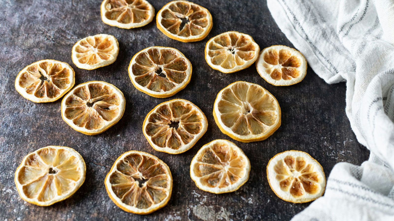 Dried lemons scattered on dark background.