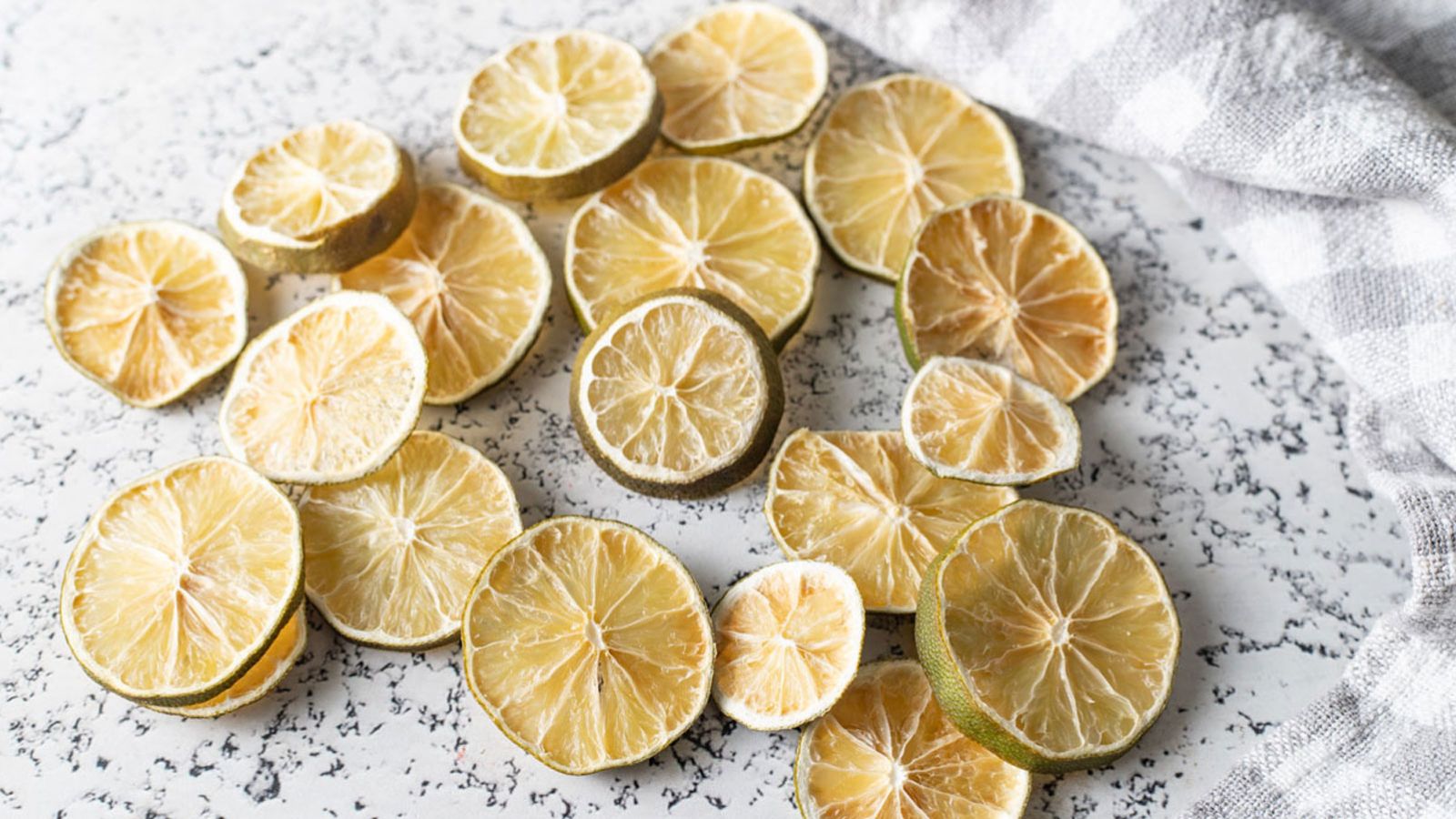 A pile of dried lime slices on light background.