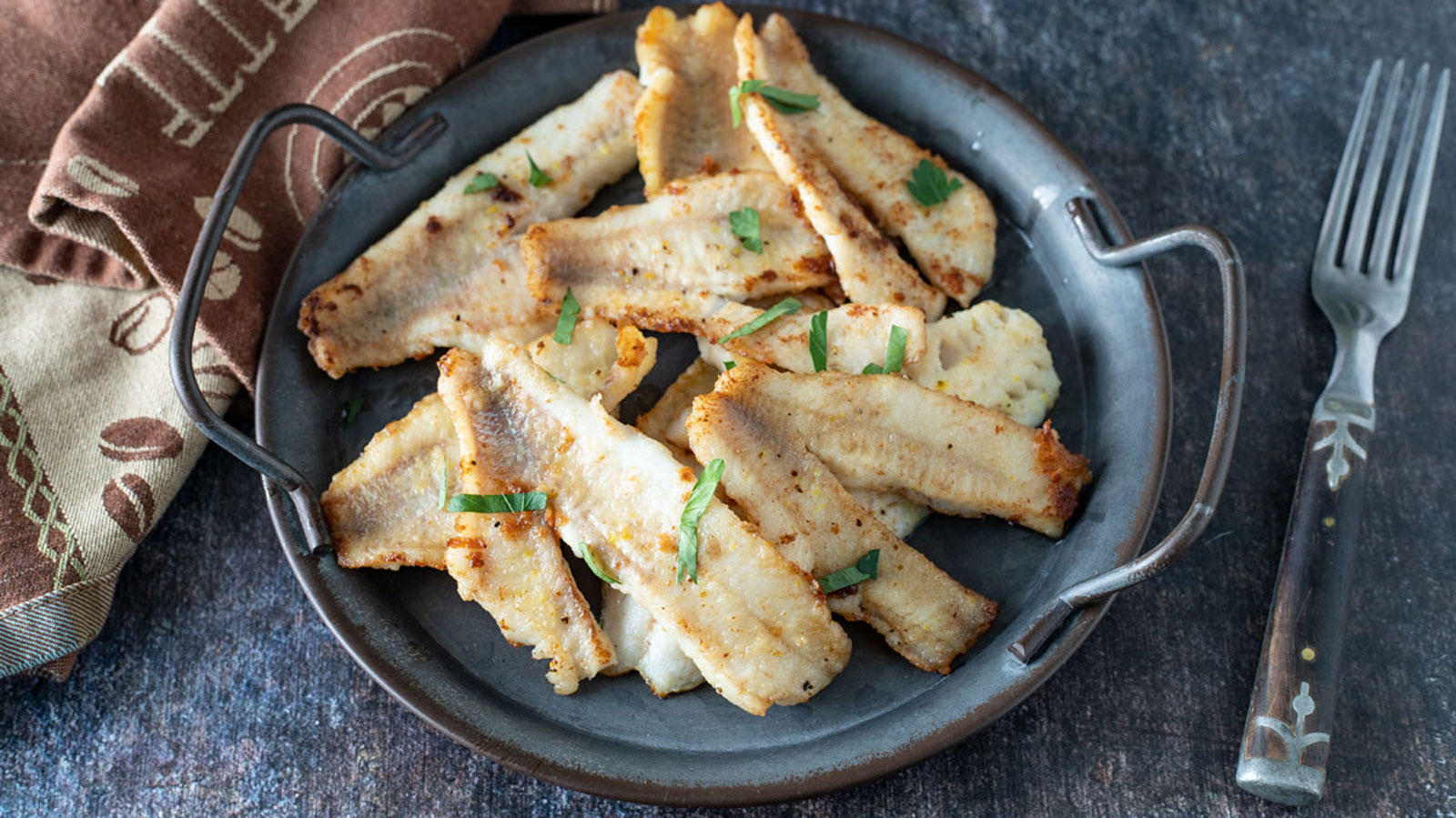 Fried perch on vintage metal plate.