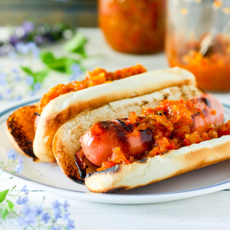 Pepper relish on a hot dog with a bun.
