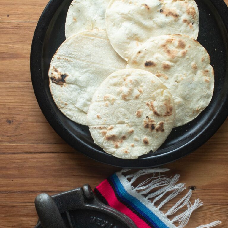 Browned tortillas on a black plate.