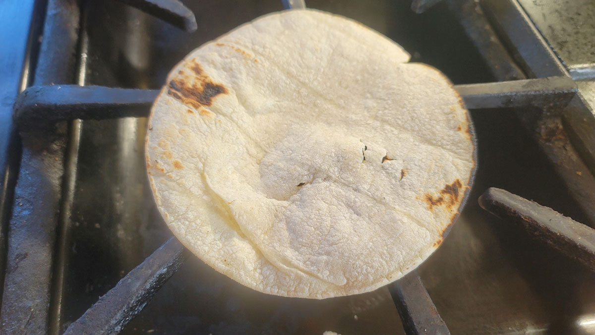 Browned tortilla flipped to the other side.