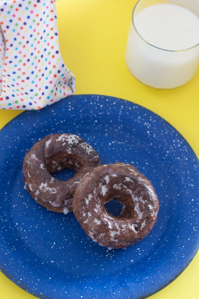 2 chocolate doughnuts on blue pewter plate