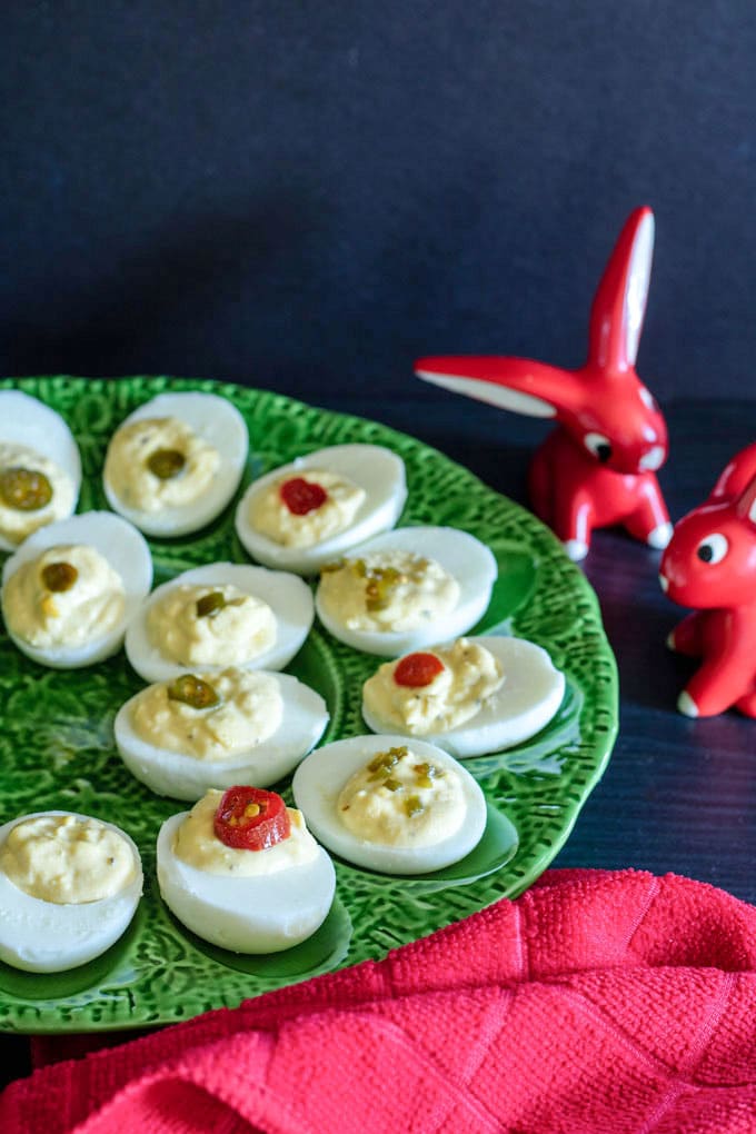 deviled eggs on green platter with red decorative rabbits