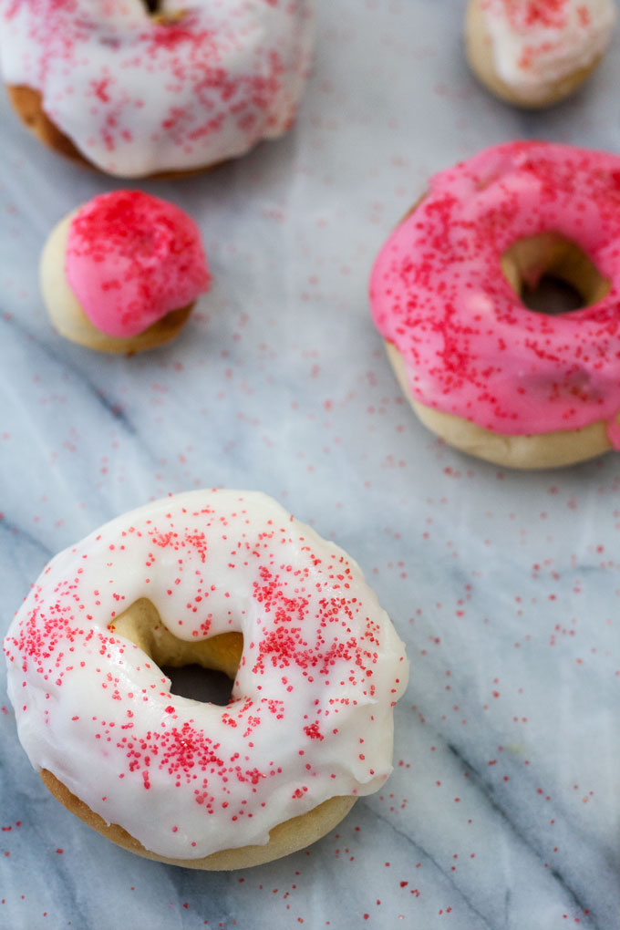 close up white frosted air fryer doughnut on marble board