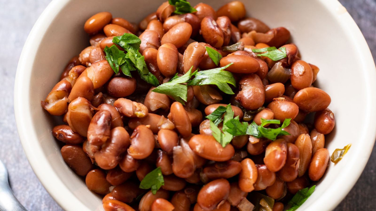 Beans in white bowl on gray background.