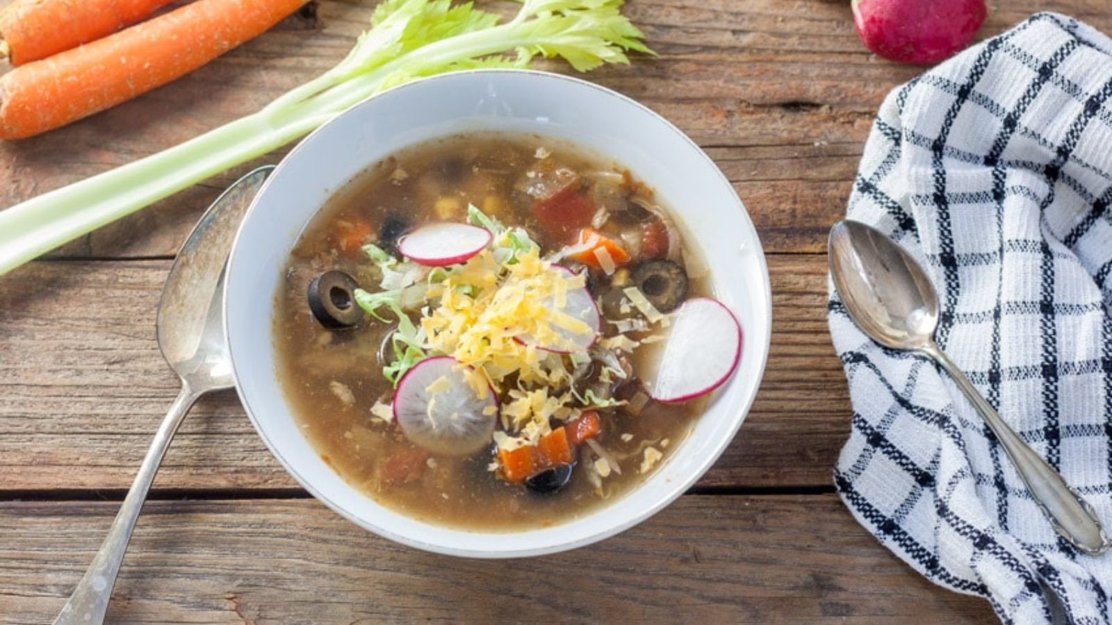 Bowl of turkey mexican soup on a wooden board.