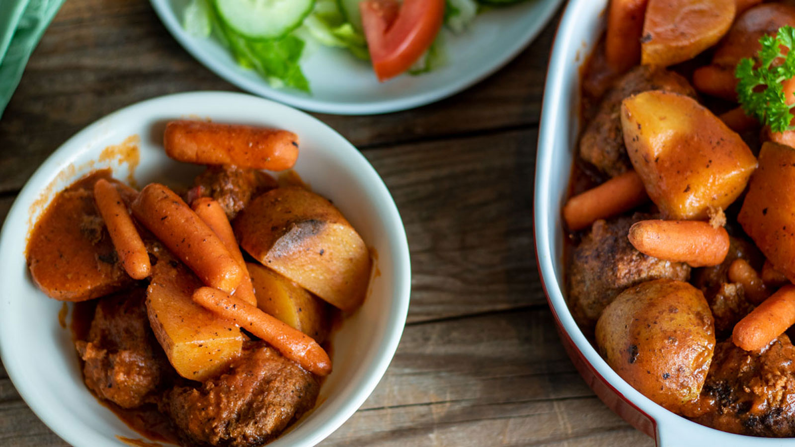 Meatball stew in a bowl with carrots.