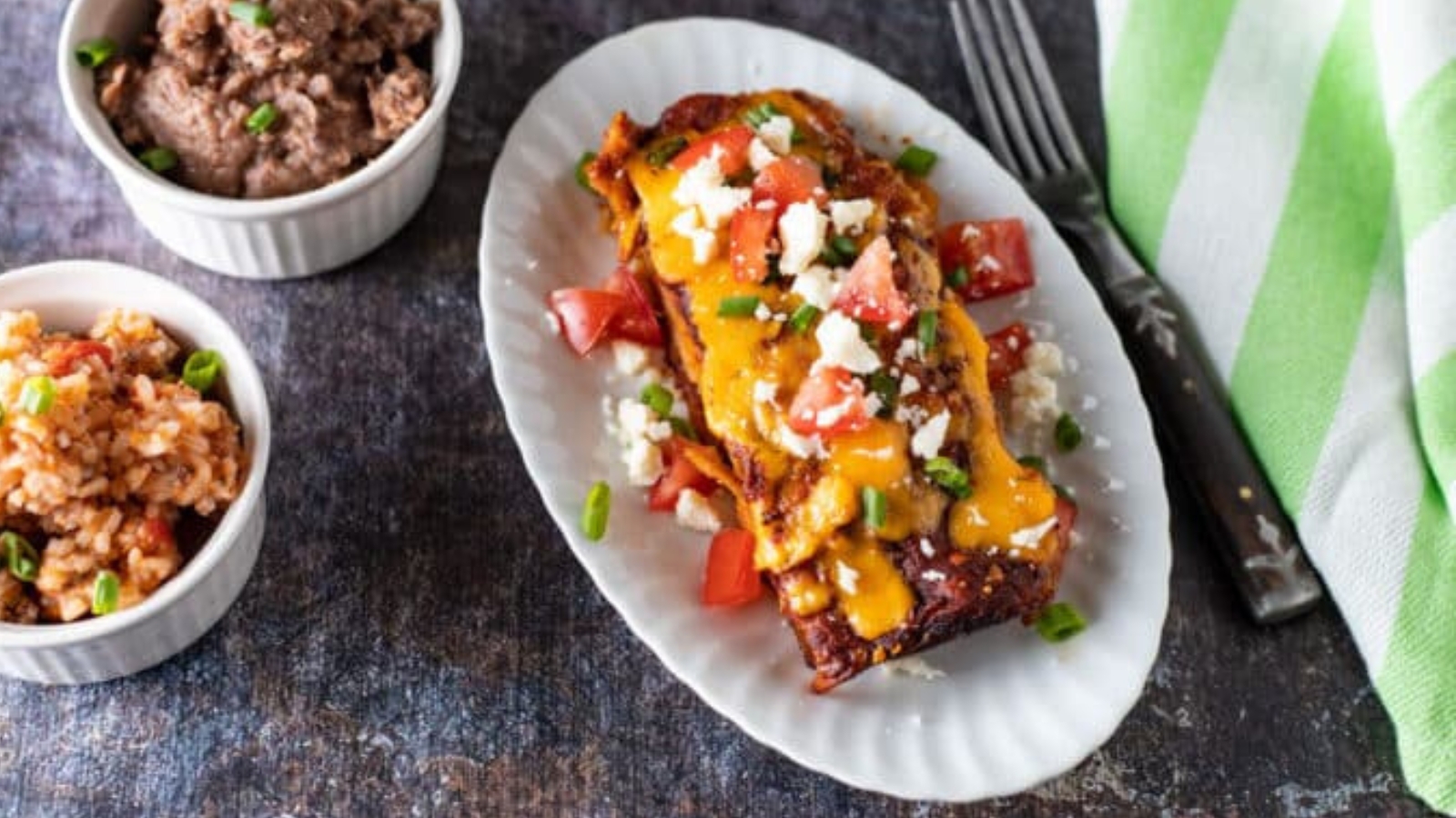 Overhead view of enchiladas with toppings.