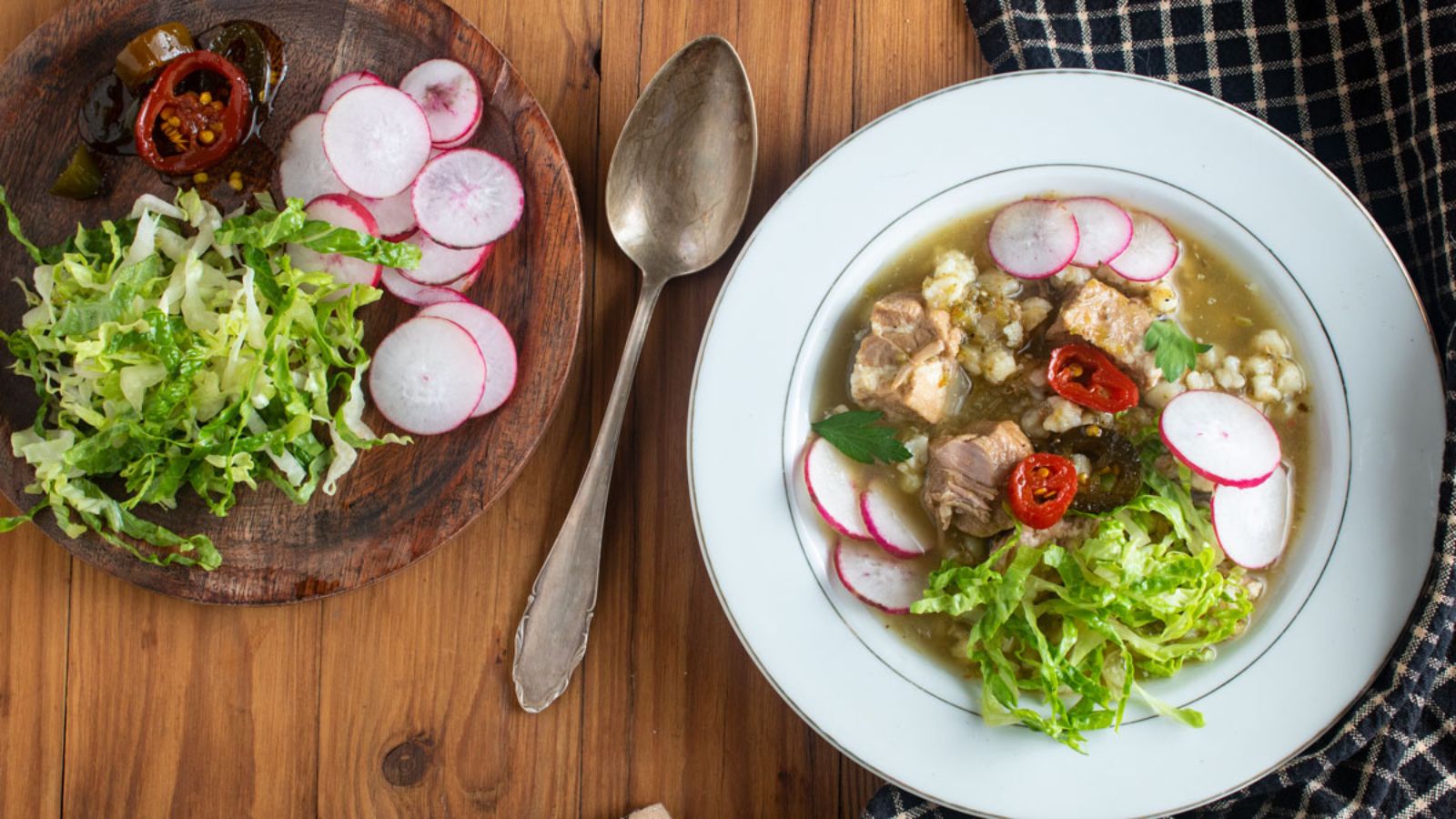 Pork soup garnished with colorful vegetables on a wood board.