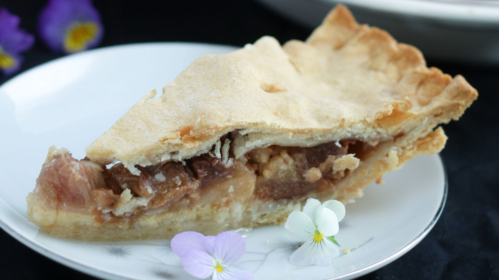 A slice of rhubarb pie on a white plate.