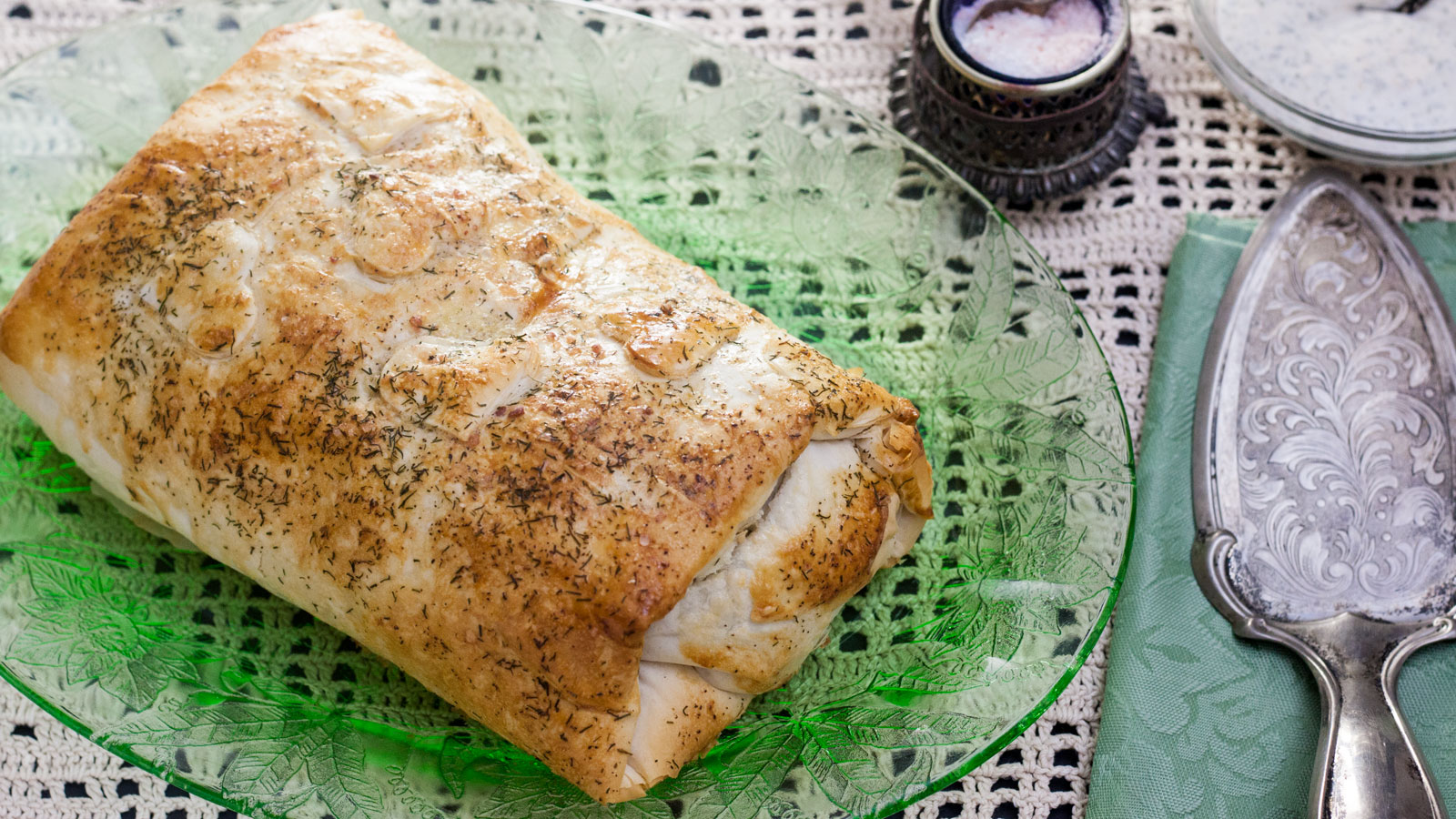 Salmon wellington served on a green glass dish.