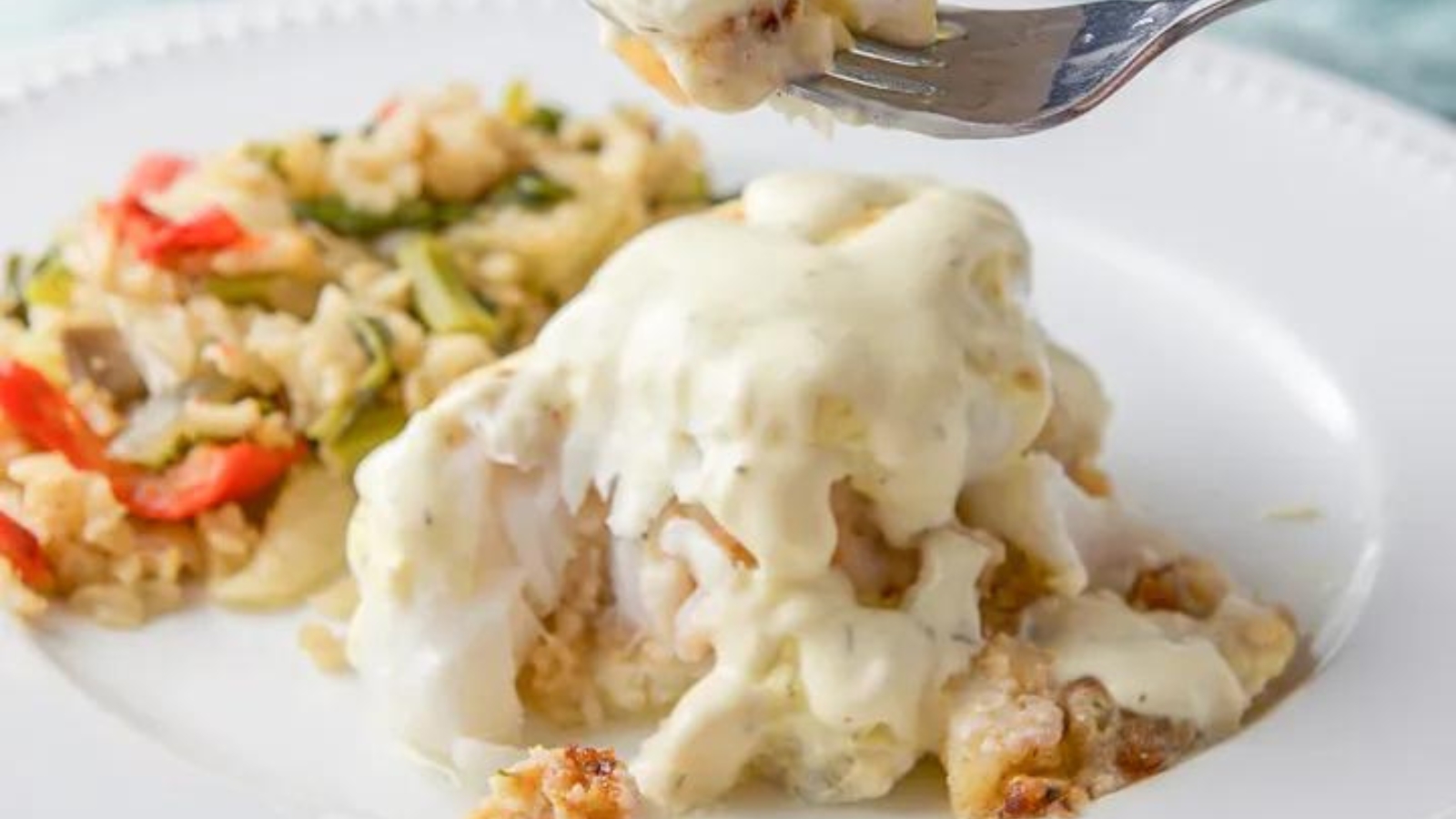 White fish stuffed with seafood and topped with white sauce.