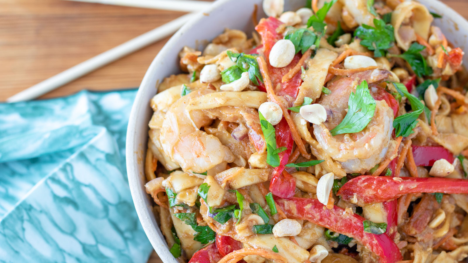 Large bowl filled with colorful shrimp pad thai.