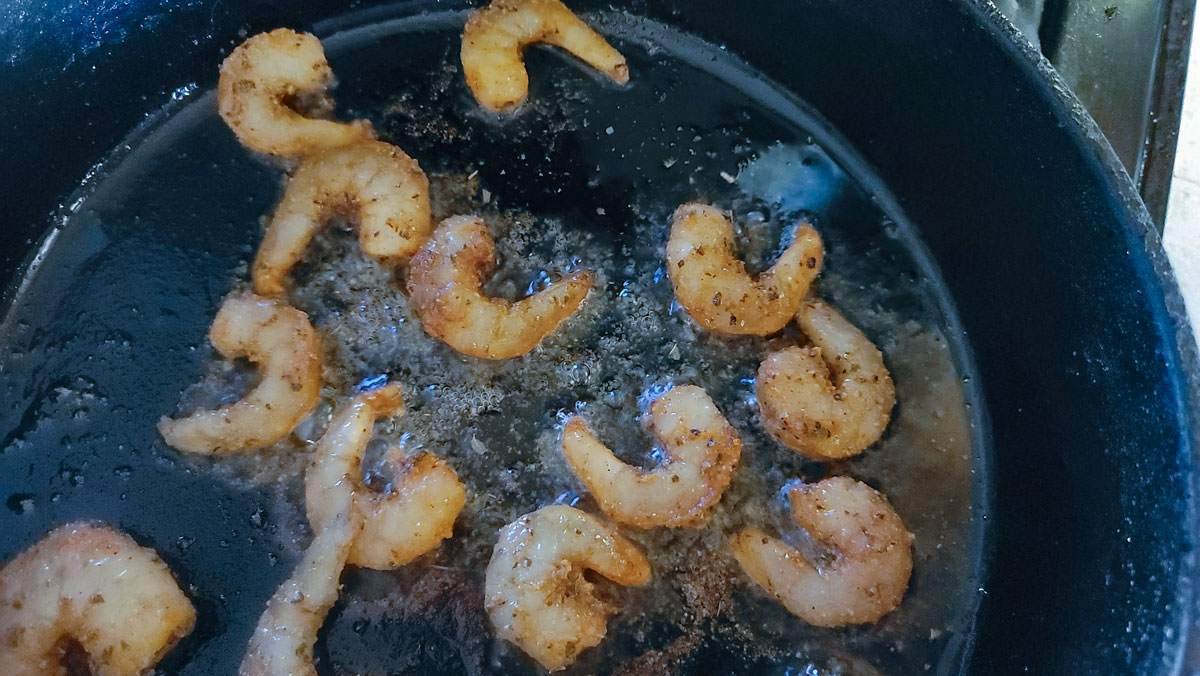 Shrimp in a frying pan with oil.