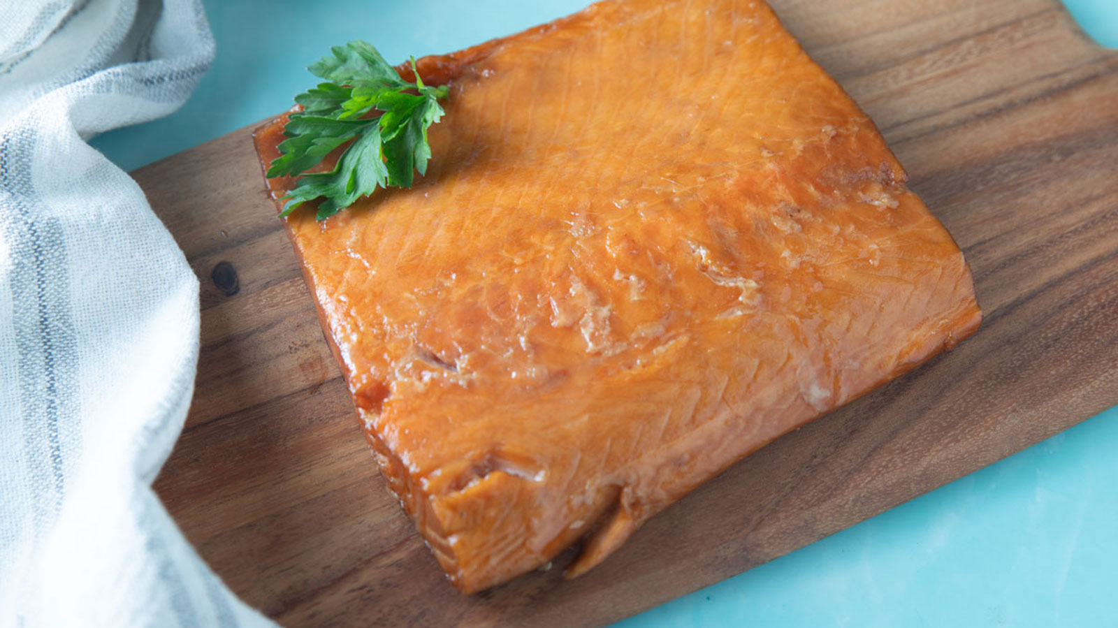 Large chunk of salmon on a wooden board.
