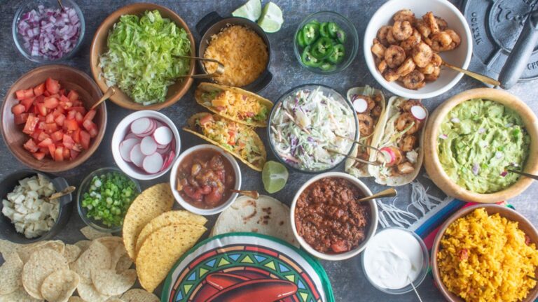 Section of a taco bar with various ramekins holding toppings and fillings.