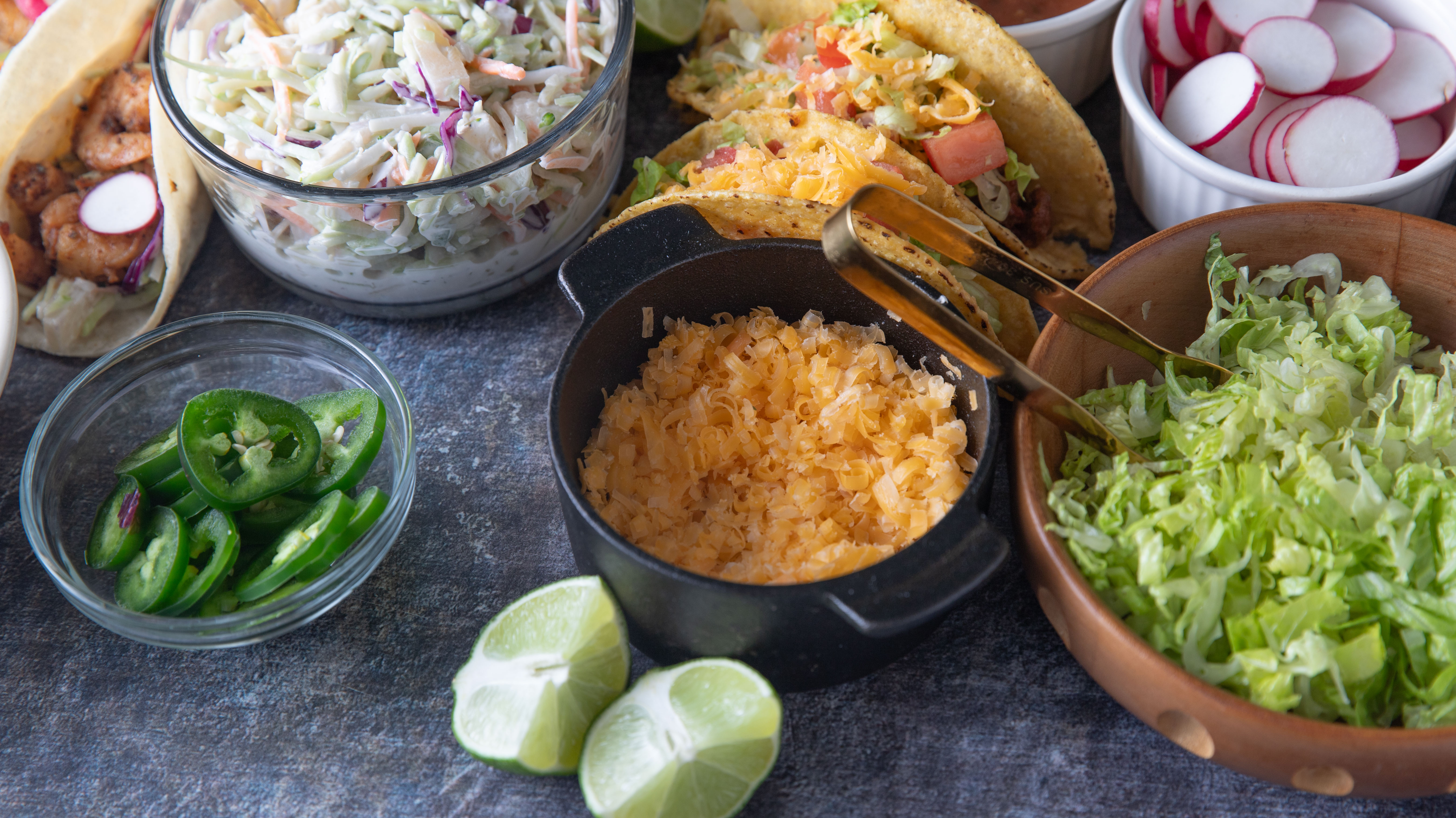 Taco toppings in small bowls and ramekins.
