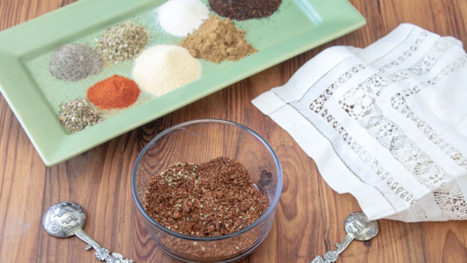 Taco seasoning as separate ingredients on a green platter in the background of a bowl of all components combined.
