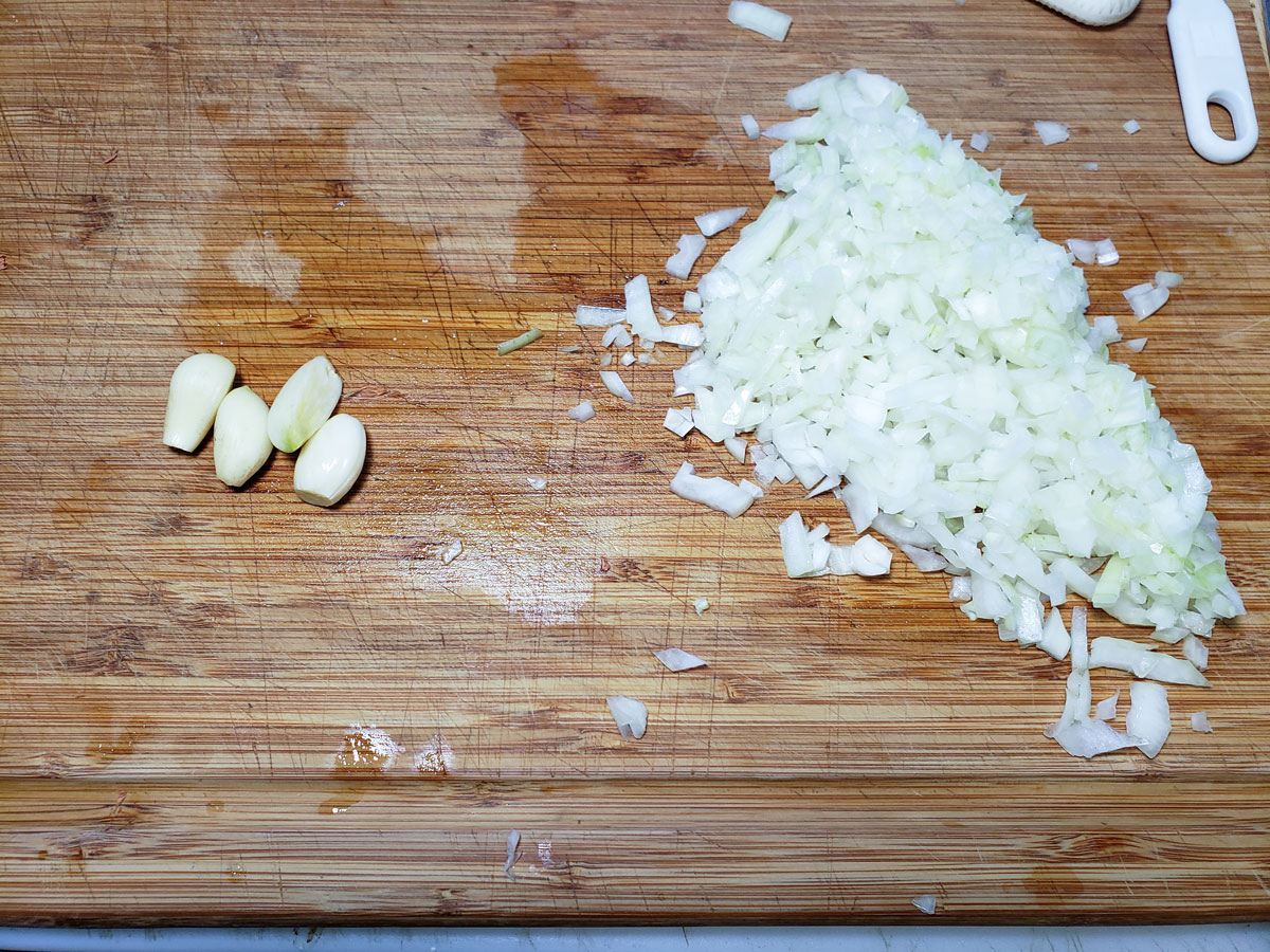 Chopped onions and garlic on the board.