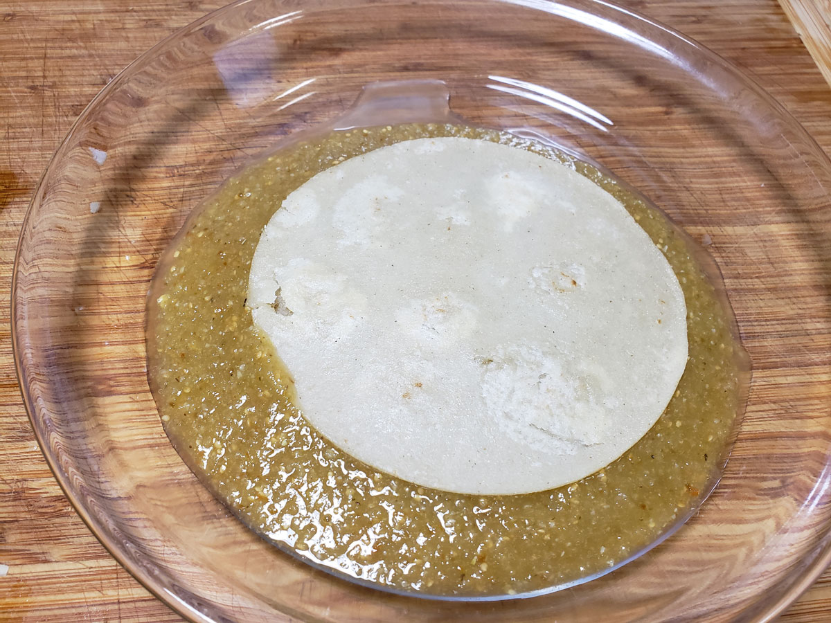Dipping tortilla in the green sauce.