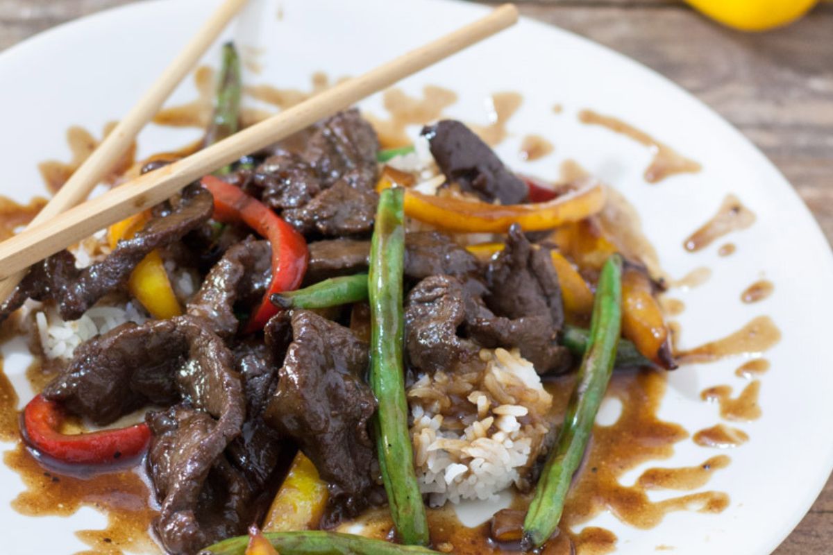 Plate of venison teriyaki on a bed of white steamed rice.