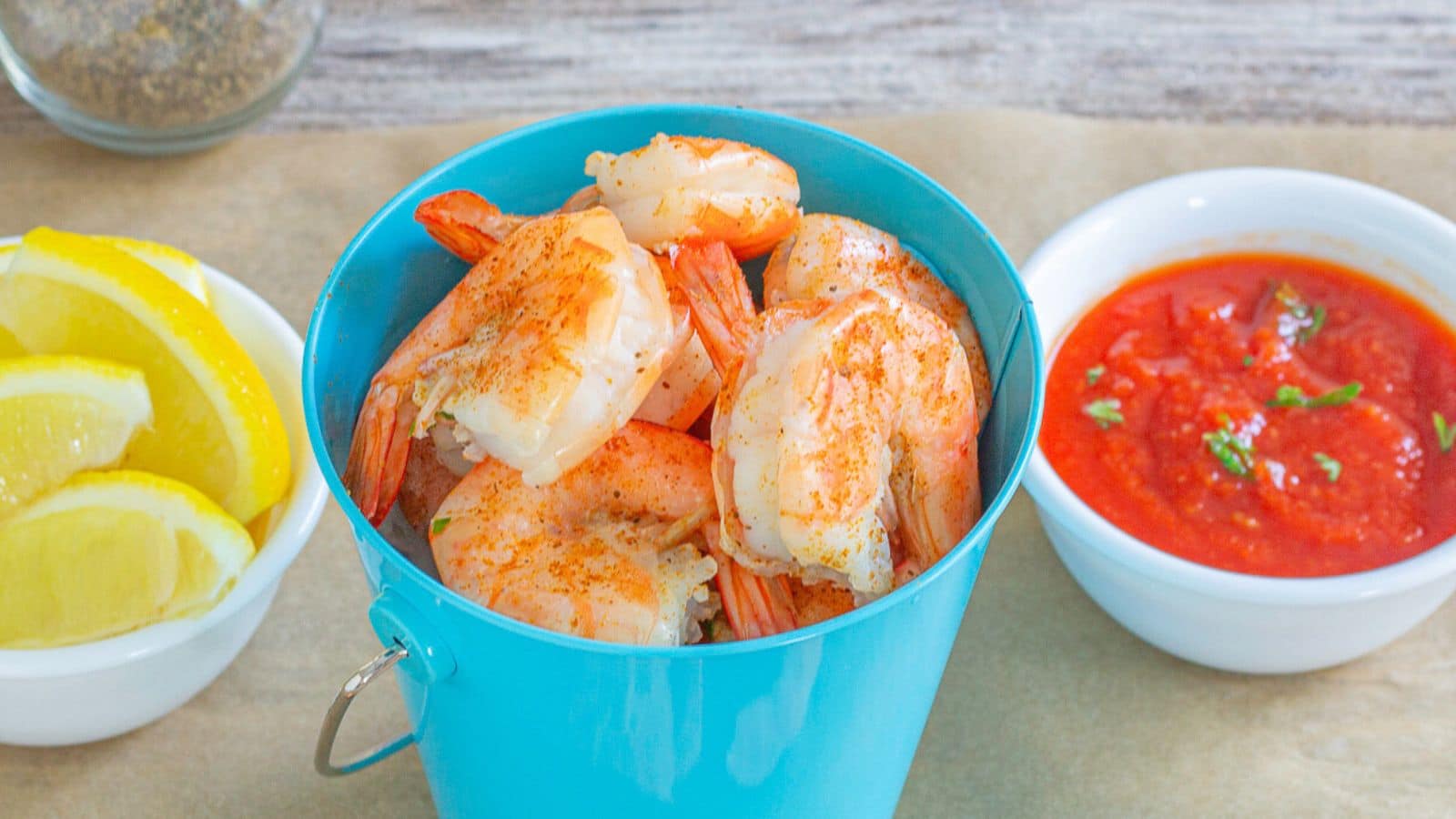 Beer boiled chicken in a bowl with dip and lemons on the side.