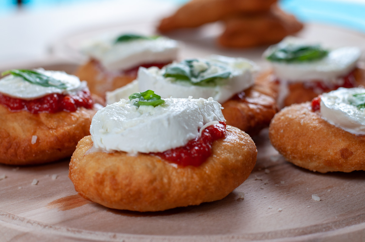Fried pizza topped with sauce and cheese.