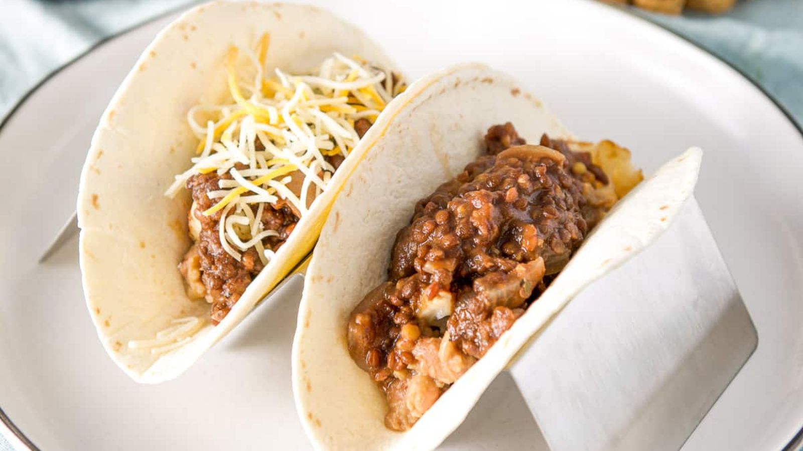Two pieces of tacos with lentils.
