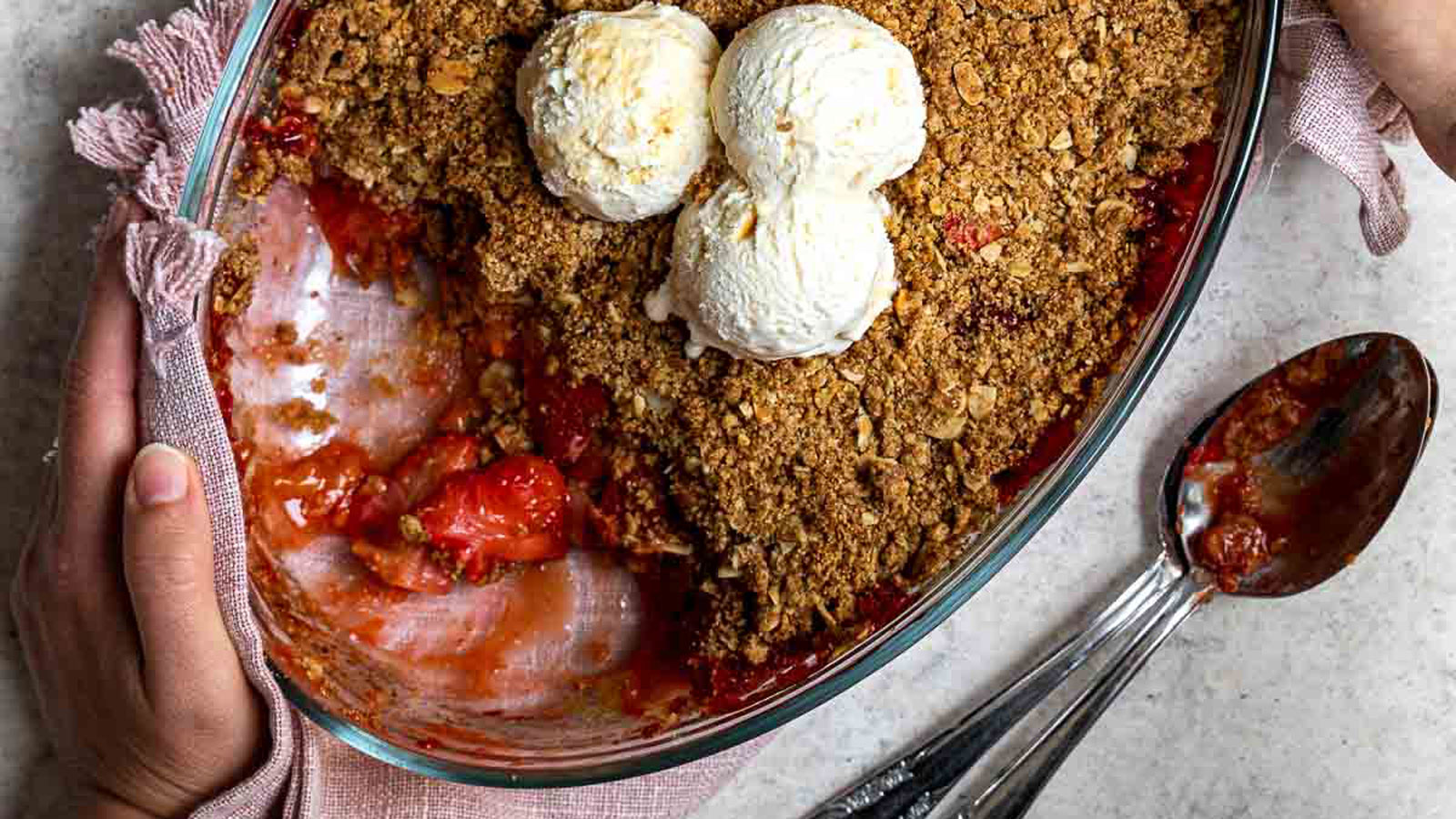 Strawberry crumble with three scoops of ice cream on top.