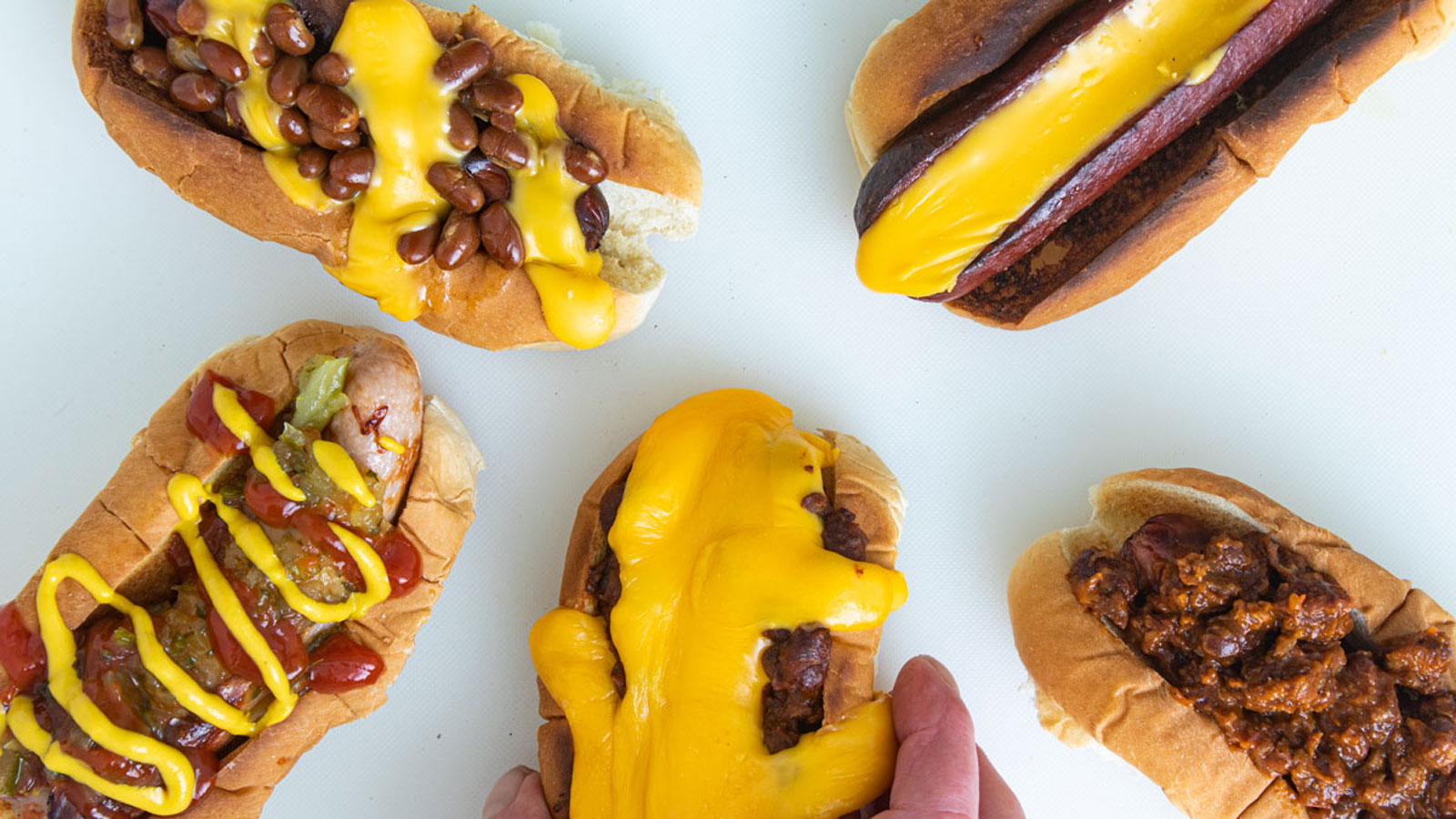 Hotdogs in a bun with sauce on top.