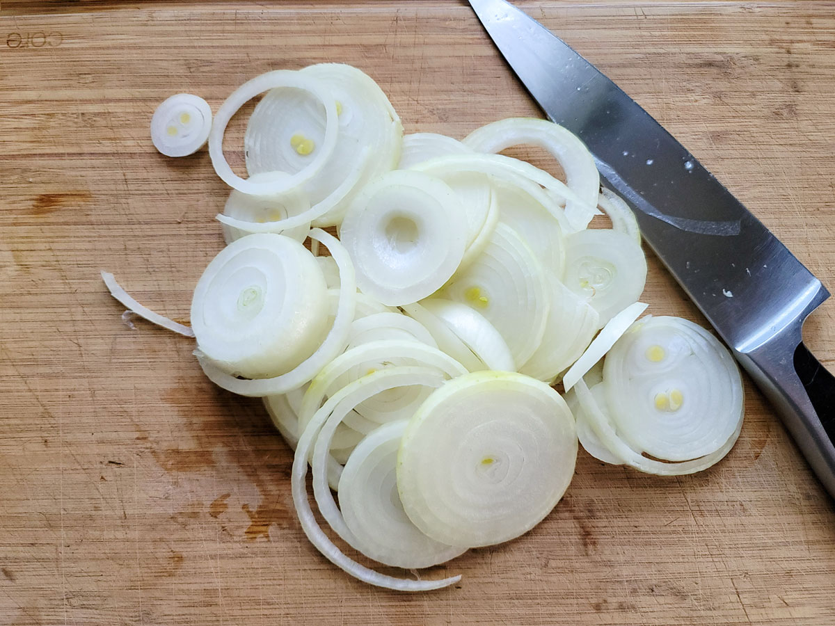 Sliced onions on a cutting board.