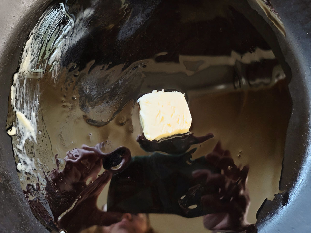 Oil and butter melting in a cast iron skillet.