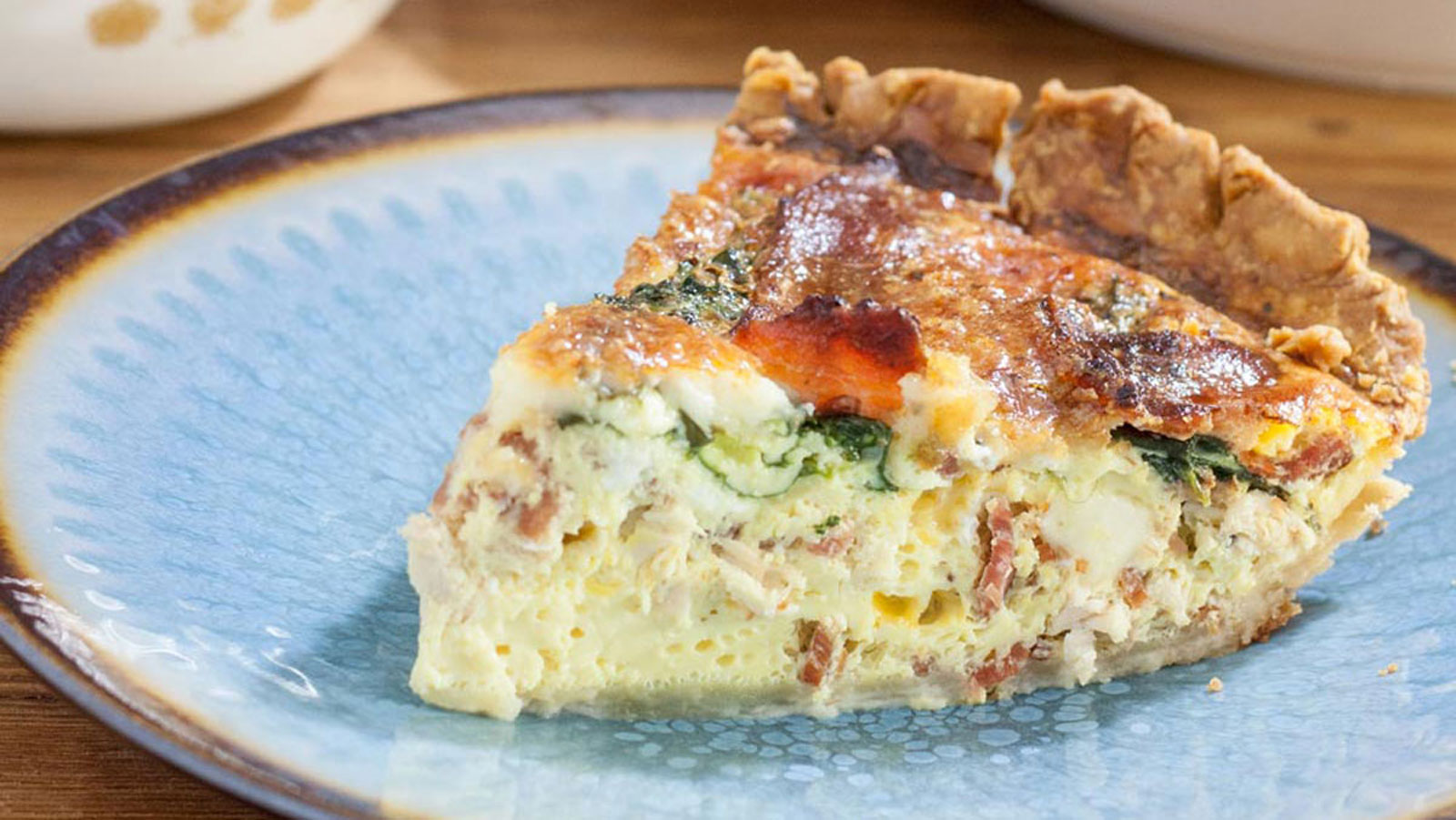 Chicken quiche slice on a blue plate.