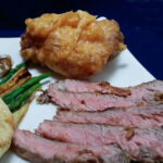 Slice chicken-fried steak on a white plate.