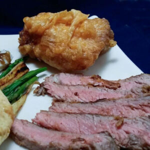Slice chicken-fried steak on a white plate.