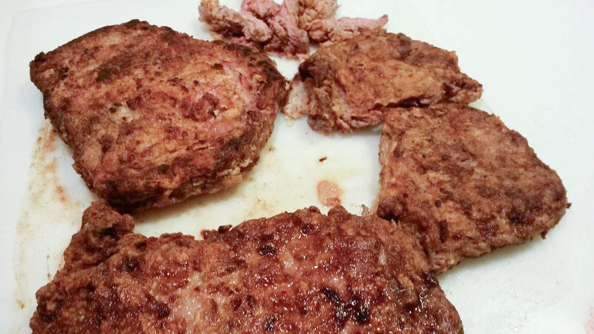 Steaks draining on paper towels.
