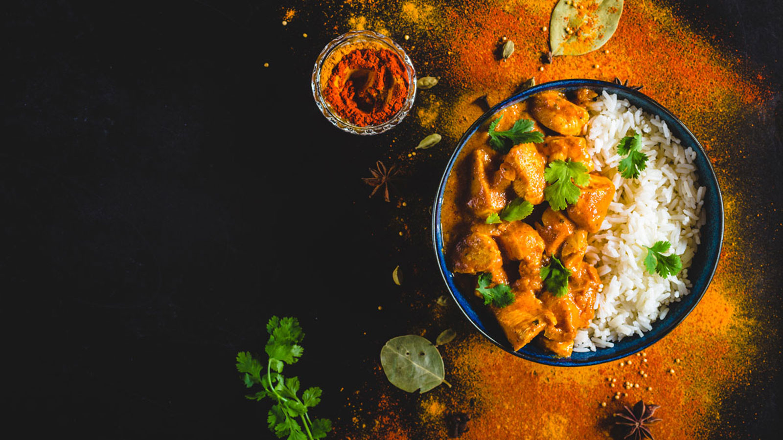 Bowl of chicken tikka masala served with white rice.