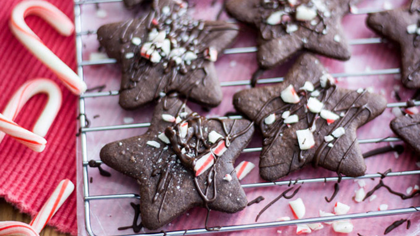 Star shaped cookies topped with peppermint pieces and drizzled with chocolate.