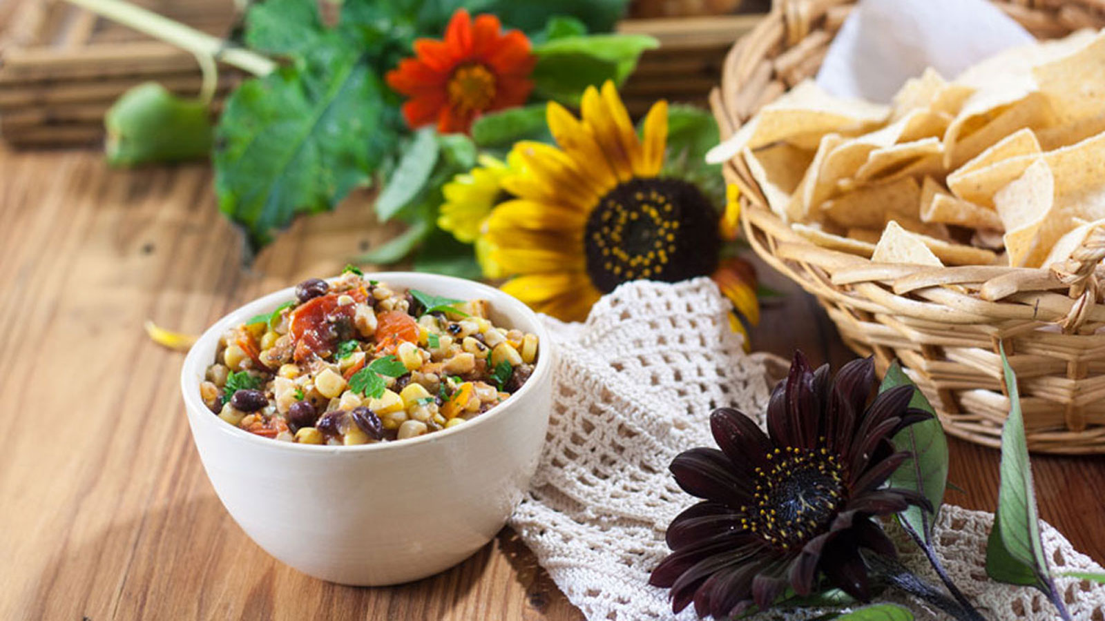 Roasted corn salsa in a small bowl, with fall flowers.
