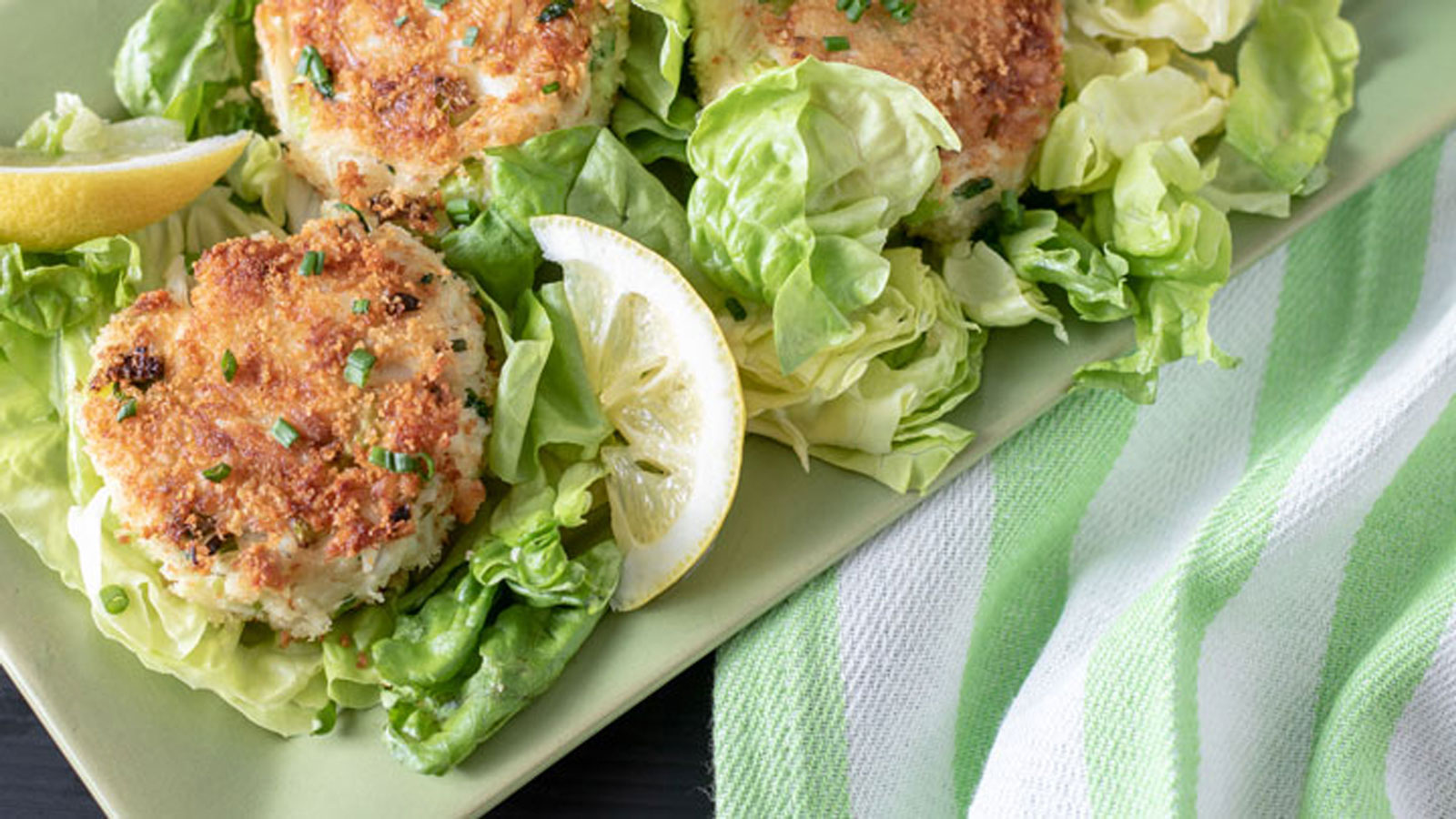 Crab cakes on green platter.