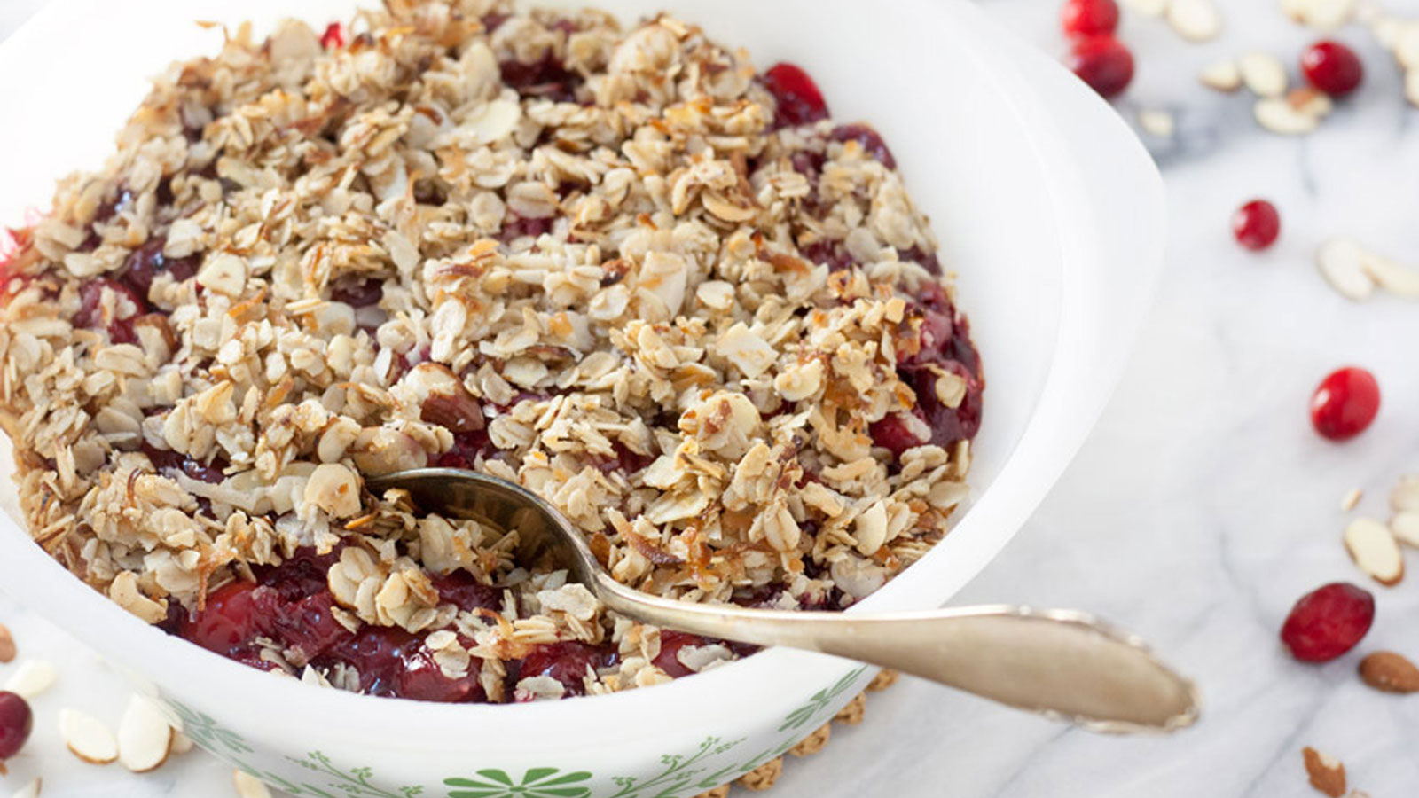 Cranberry cherry crisp in a bowl with spoon.