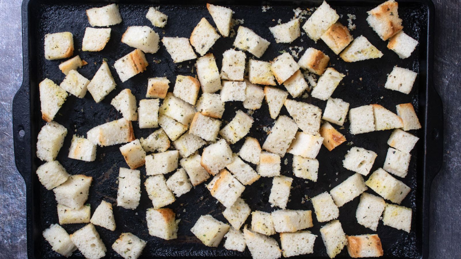 Unbaked croutons on antique baking tray.