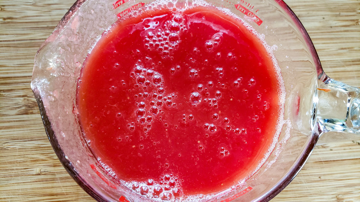 Tomato juice in a measuring cup.