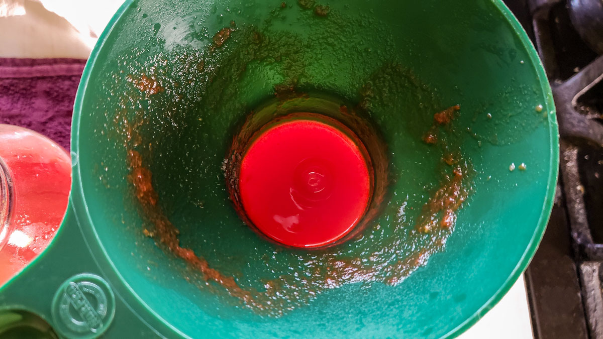 Filling the jars with a canning funnel.