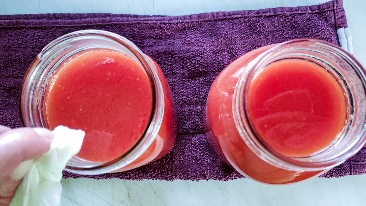 Cleaning off the rims of the jars.