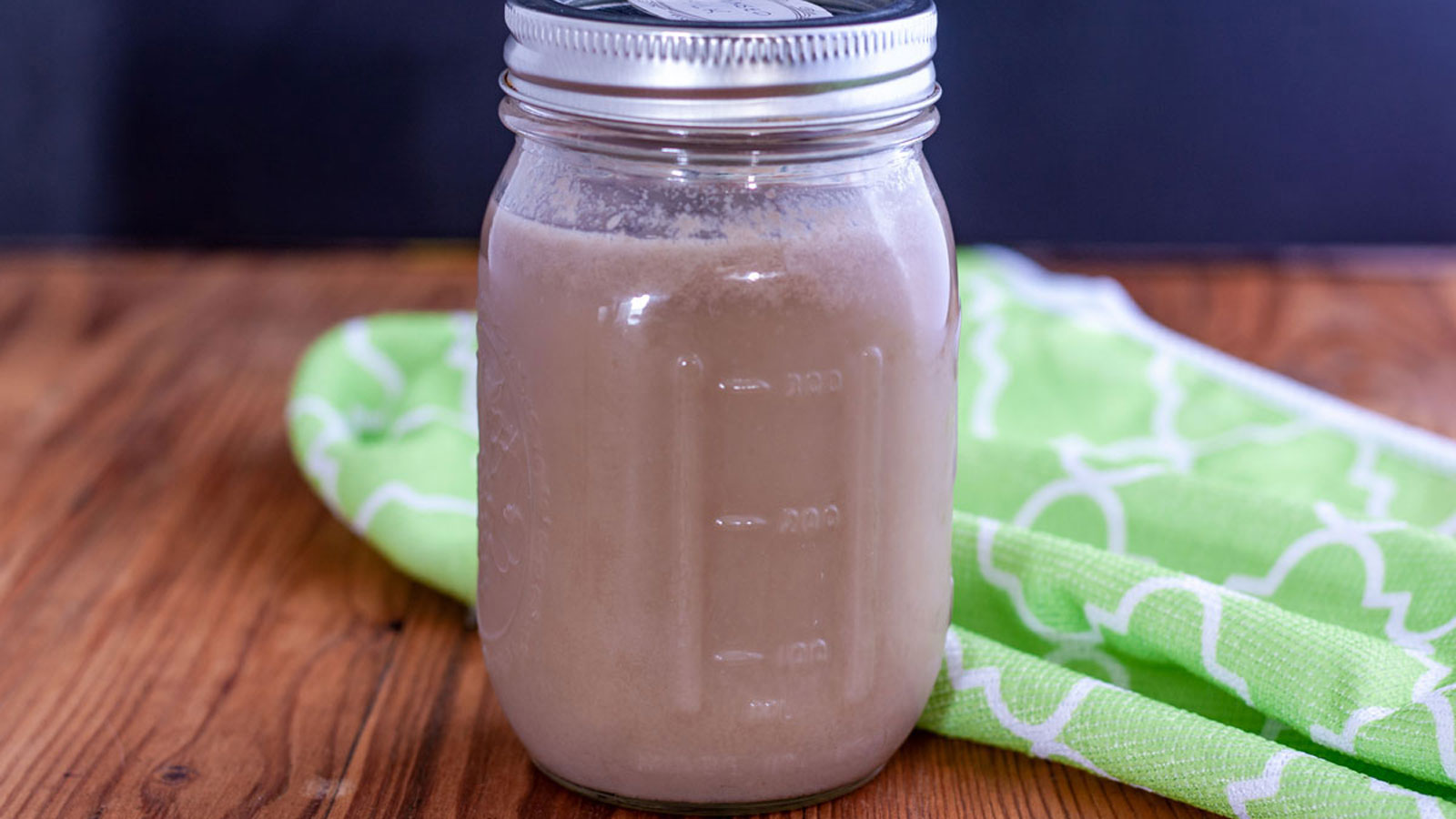 Jar filled with milk with spoon.